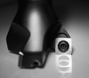 Close-up black and white photo of CNC boring head featuring cylindrical body, white adjustment dial with graduations, and visible cutting insert holder